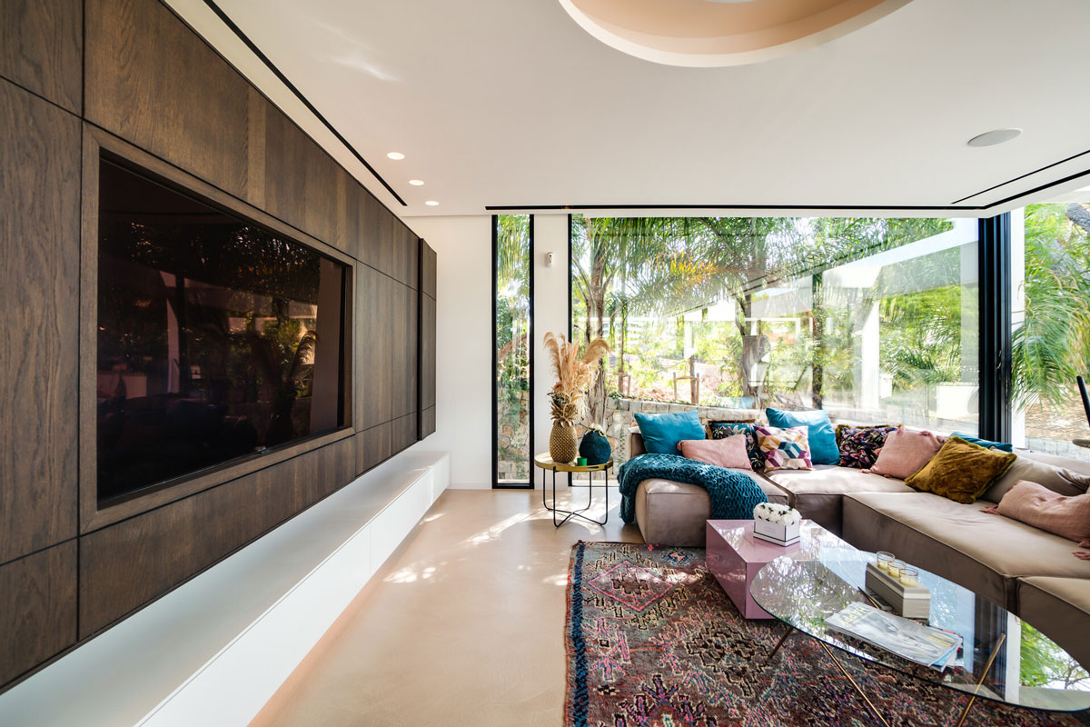 Wohnbereich mit Holzvertäfelung und integriertem TV in moderner Villa Mallorca